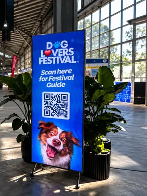 Freestanding digital sign displaying Dog Lovers Festival information and a dog image.