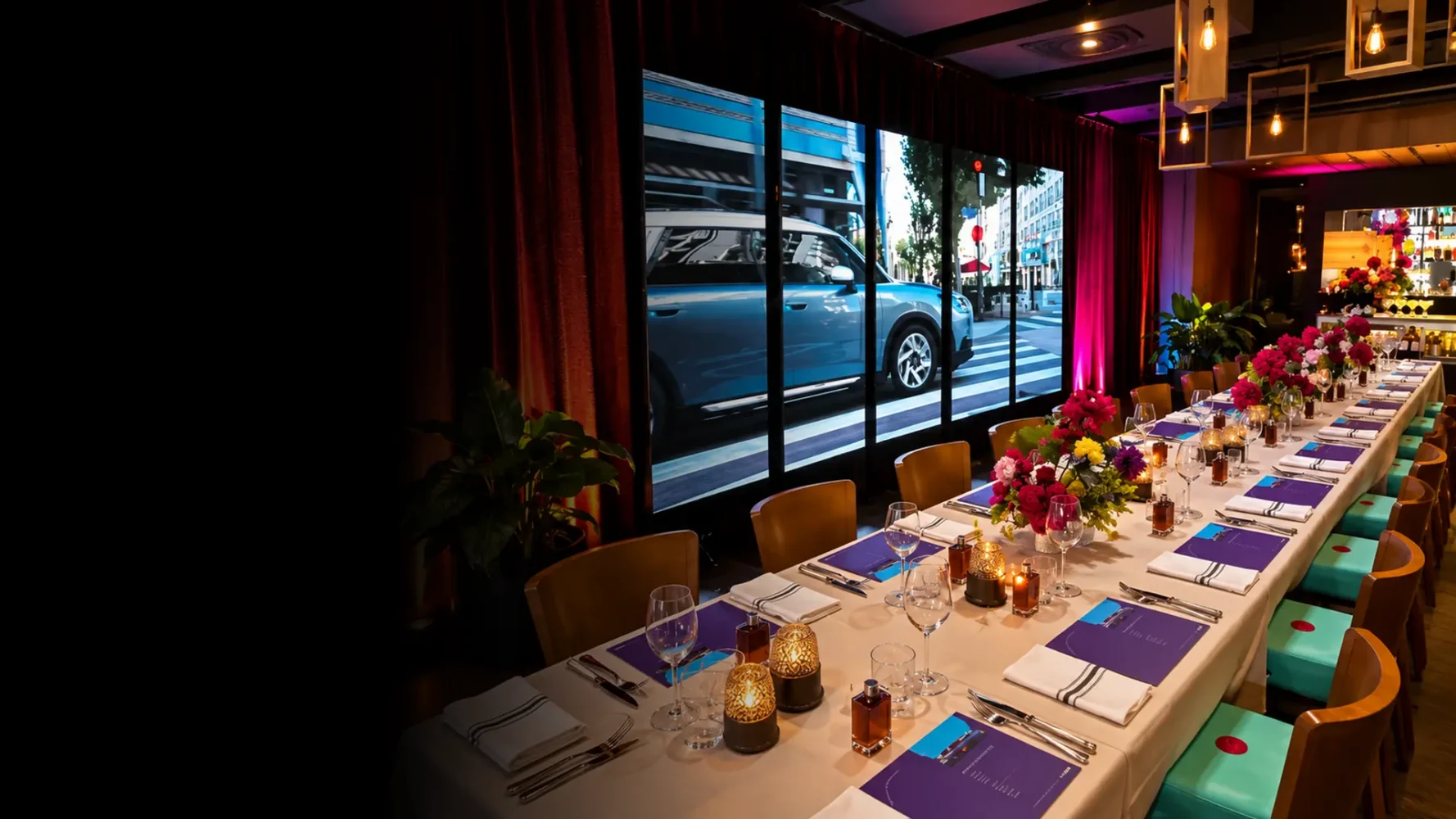 LED video wall hire for a corporate dining event, displaying automotive content beside a professionally styled table.