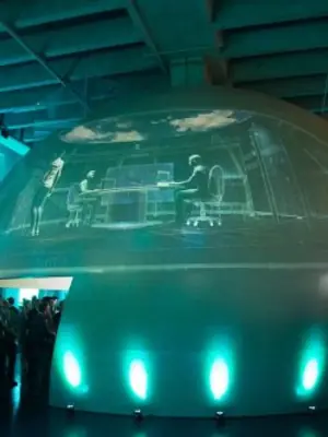 Projected graphics across a large event dome illuminated by turquoise uplights.